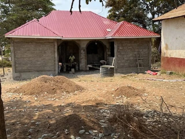 Computer Learning Center with block walls and a red corrugated roof; construction remains incomplete